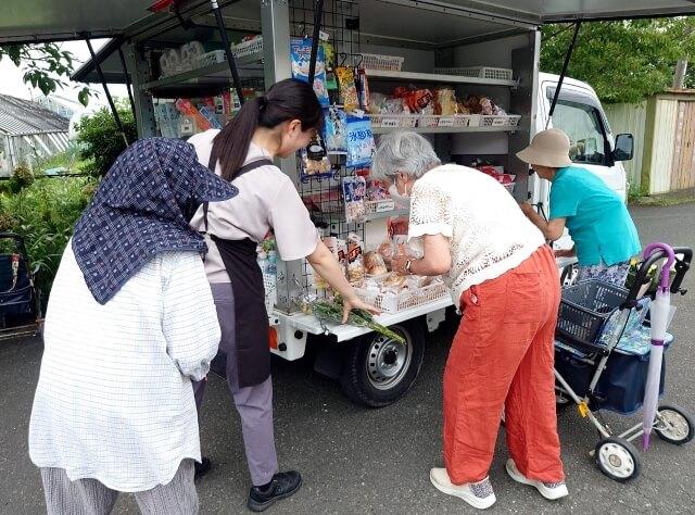 写真5、移動販売スタッフと地域の皆さんが会話している写真。販売スタッフとの会話がもうひとつの楽しみ。